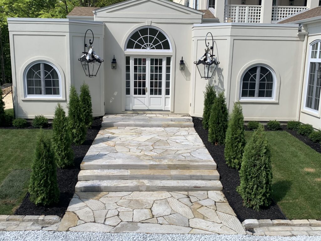 Escaliers et balcons en pierre formant une allée vers une porte d'entrée